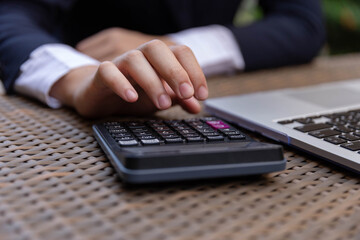 Businessman concept the male accountant using the calculator to check the correctness of the numerical data in the info chart on the wooden table