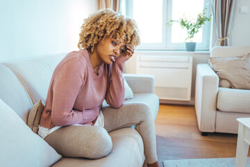 Young woman in stress. Young woman massaging head while suffering from headache at home. Getting detached. Close up of young stressed woman keeping her eyes closed while touching her temples