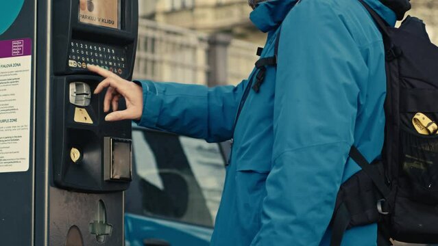 Man paying ticket, parking machine on street in Prague, easy way to park anywhere