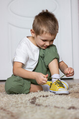 a small child ties his shoelaces