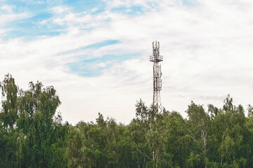 Cell tower against a blue sky with clouds.