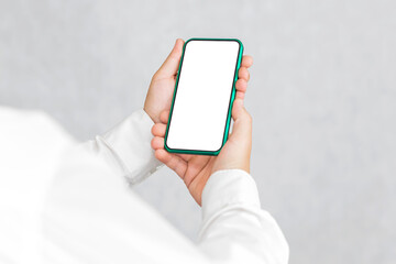 Mockup of a green smartphone in the hands of a man. On a light background.