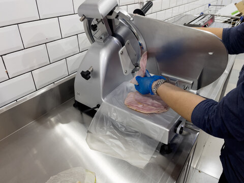 Slicing ham in a slicer machine - Powered by Adobe