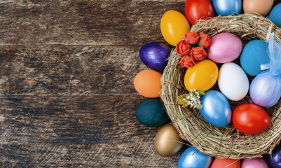Fototapeta na wymiar multi colors painted easter eggs in decor nest. Happy Easter holiday card