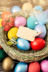 multi colors painted easter eggs in decor nest. Happy Easter holiday card 