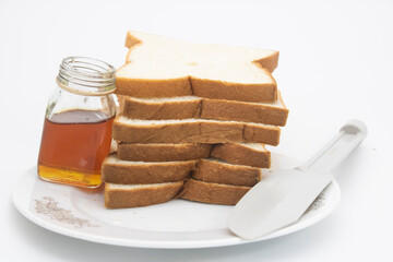 selective focus on honey dipper with slice bread isolated on white background