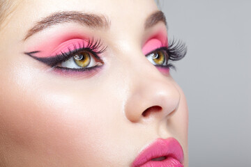 Fototapeta premium Closeup macro shot of human female face with pink makeup