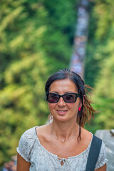 Happy woman crossing Capilano Cliff Walk Suspension Bridge in Vancouver.