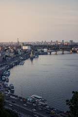 Naklejka premium Kyiv, Ukraine. View of the embankment, bridges and Dnipro river, Podil in the evening.