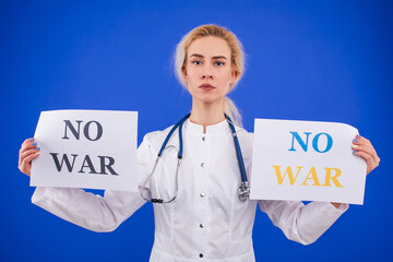 A female doctor holds two no war posters on a blue background