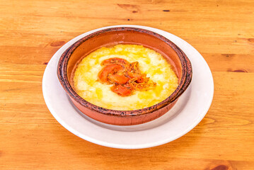Gran receta italiana para una porción de queso provolone a la parrilla en una olla de barro con tomate y pimiento picado en el centro de la comida