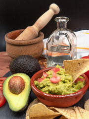 Homemade Organic Guacamole, tequila and Tortilla Chips. Selective focus.