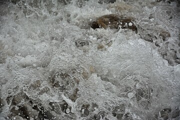 Water churning as the waves crush on the sandy beach