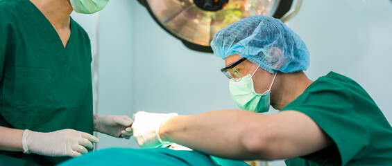Asian Professional surgeons team performing surgery in the operating room, surgeon, Assistants, and Nurses Performing Surgery on a Patient, health care cancer and disease treatment concept