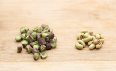 red color fresh yardlong bean pieces over on wood background