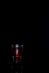 glass of cherry liqueur, alcohol, black background