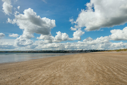 Tramore beach in the Republic of Ireland on a spring day with many clouds