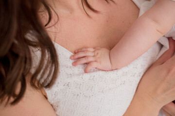 close-up of the child's hand lying on the mother's chest