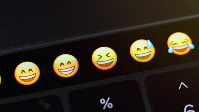 Selects the mock emoji from a range of other emoji on the laptop and sends the emote