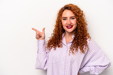 Young ginger caucasian woman isolated on white background smiling cheerfully pointing with forefinger away.