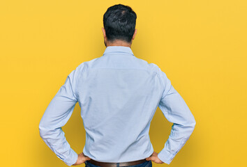 Fototapeta na wymiar Middle aged man with beard wearing business shirt standing backwards looking away with arms on body