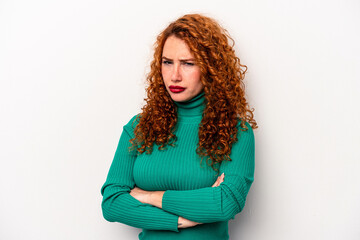 Young ginger caucasian woman isolated on white background frowning face in displeasure, keeps arms...