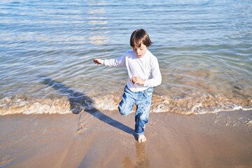 Down syndrome kid running with relaxed expression at beach