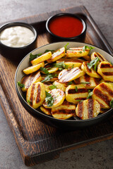 Vegan cuisine Grilled potatoes with sauces served on a wooden board on the table closeup. Vertical