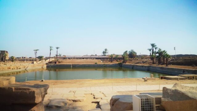Sacred royal lake in the Karnak Temple, Luxor Egypt. 
Static shot with blue skies.
