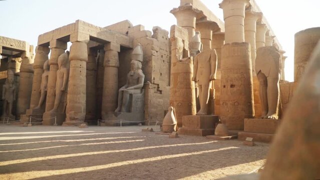 Tourist path through the Karnak Temple in Luxor, Egypt. Large pillars and tall statues with fences around.
Sideways slide with rock in the foreground.