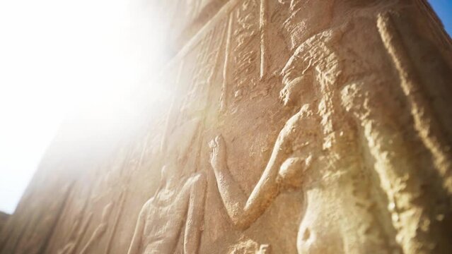 Detailed stone carving in the Karnak Temple. An egyptian queen with a hand reaching towards a soft sun flare.
Slow rotation. 