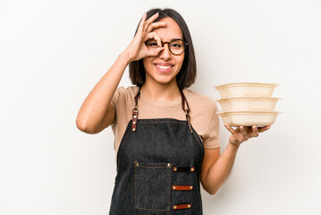 Young caucasian waitress woman holding tupperware isolated on white background excited keeping ok gesture on eye.