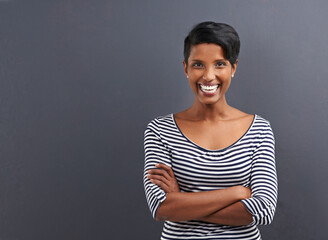 Casual confidence. Portrait of a happy young woman standing on a gray background.
