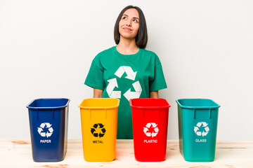 Young hispanic woman recycling isolated on white background dreaming of achieving goals and purposes