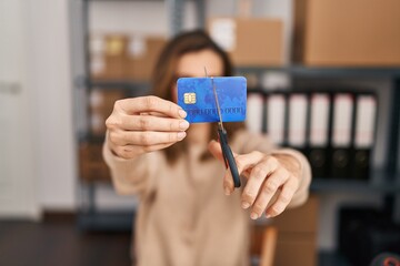 Young woman ecommerce business worker cutting credit card at office