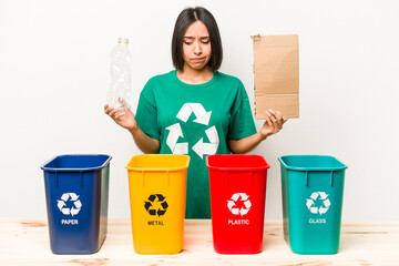 Young hispanic woman recycling cardboard isolated on white background