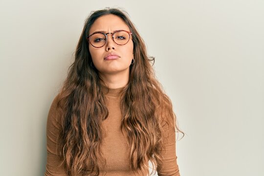 Young hispanic girl wearing casual clothes and glasses depressed and worry for distress, crying angry and afraid. sad expression.