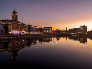 Fototapeta na wymiar Sunset in Cork City Ireland business and classic buildings with reflection on the river