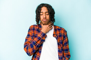 Young African American man isolated on blue background suffers pain in throat due a virus or...