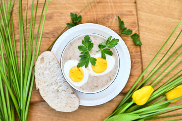 Traditional Polish soup served with bread and eggs. Easter decoration. Sour soup