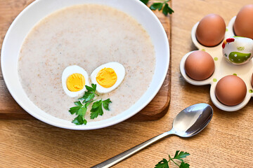 Traditional Polish soup served with bread and eggs. Easter decoration. Sour soup - obrazy, fototapety, plakaty