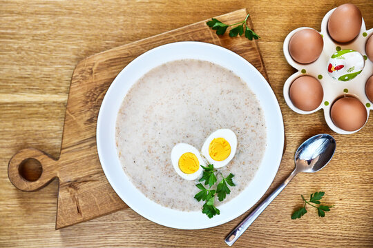 Traditional Polish soup served with bread and eggs. Easter decoration. Sour soup
