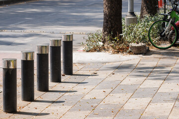 steel bollard on concrete footpath in daytime.