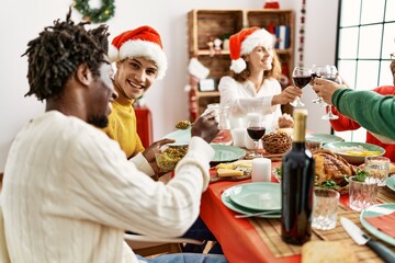 Group of young people smiling happy having christmas dinner at home.