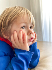 Close up portrait of beautiful little boy watching television at home.