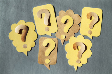 Question mark on speech bubbles, gray background.