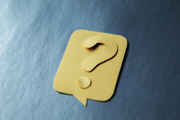 Question mark on yellow speech bubble, gray background.