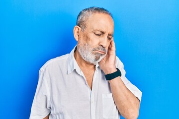 Handsome senior man with beard wearing casual white shirt thinking looking tired and bored with depression problems with crossed arms.