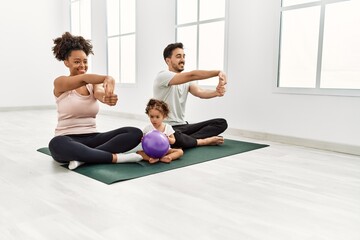 Fototapeta na wymiar Couple and daughter smiling confident stretching at sport center