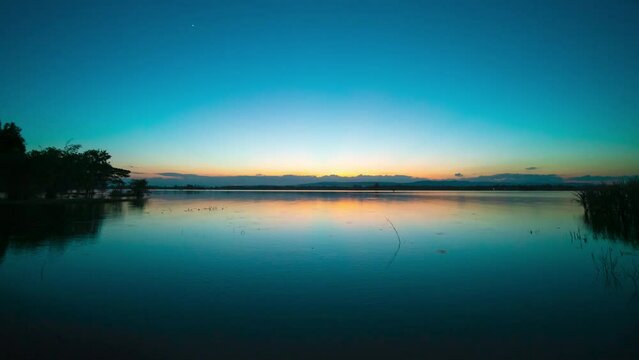 Time lapse video 4K. Nature video High quality footage. Scene of Colorful romantic. Day to night sky sunset over lake with Moving clouds background. time lapse day to night in nature and travel